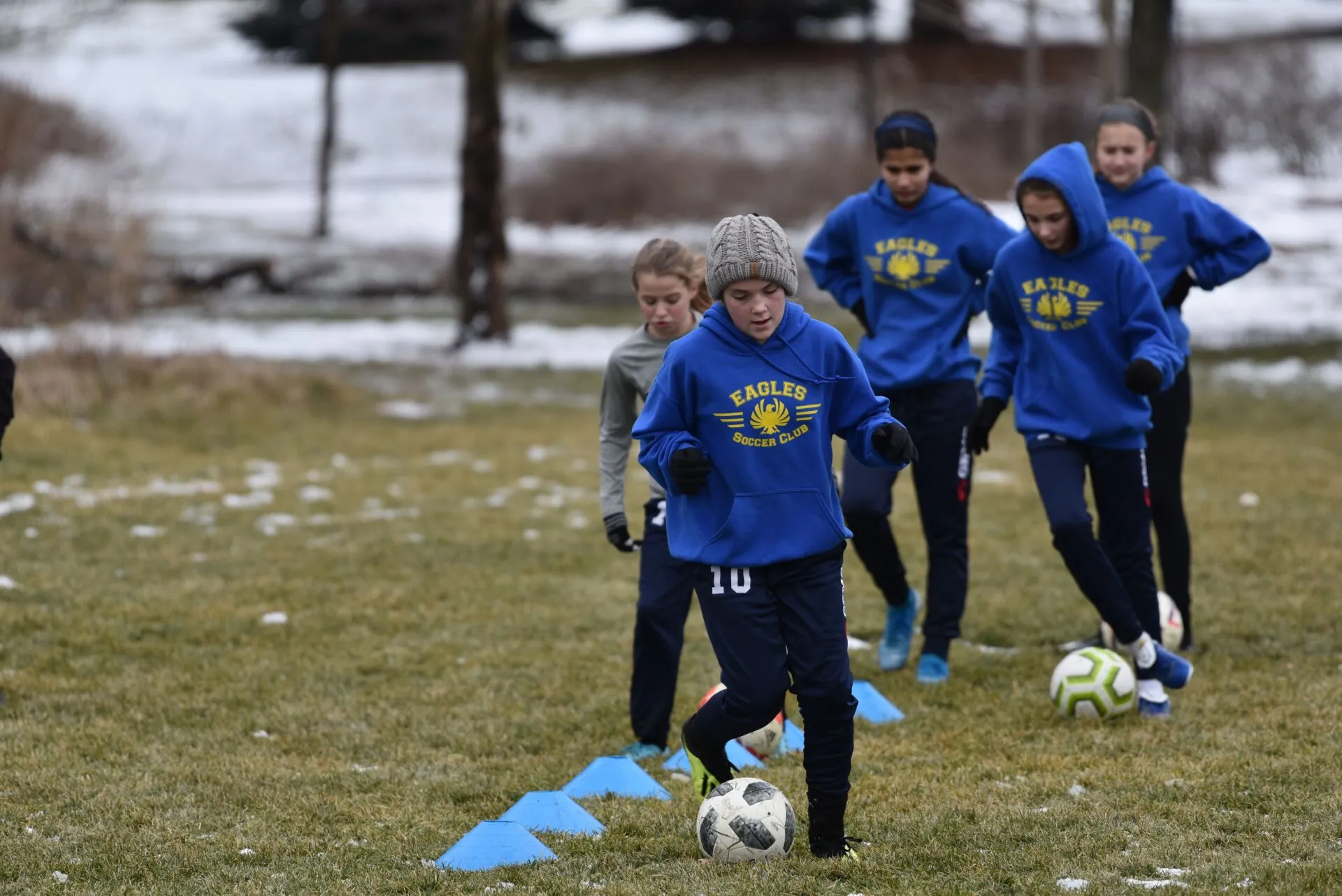 Naperville Eagles players training with soccer balls during winter