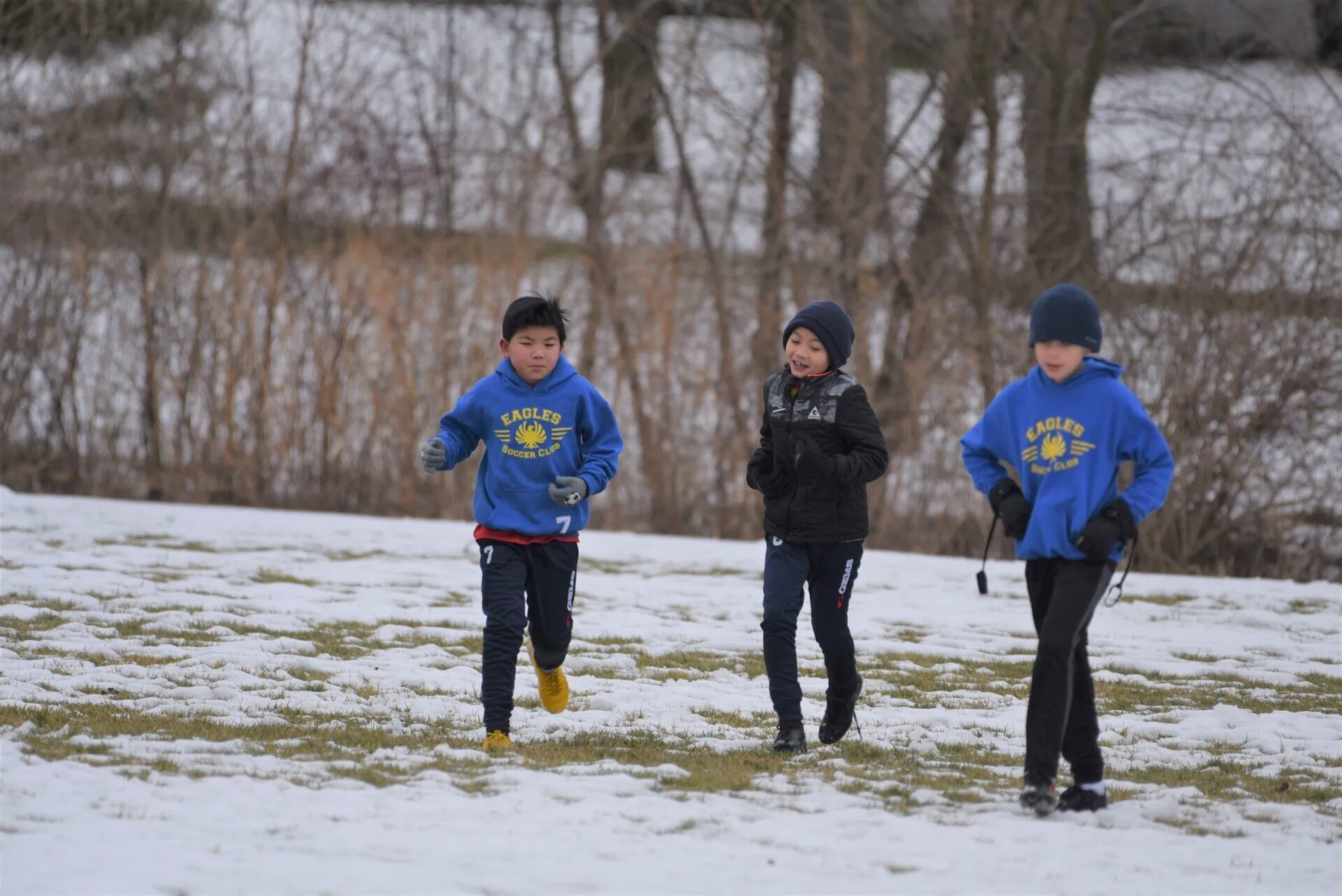 Youth soccer players practicing outside during winter